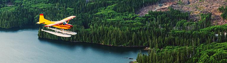 A float plane flies over coastal Alaska